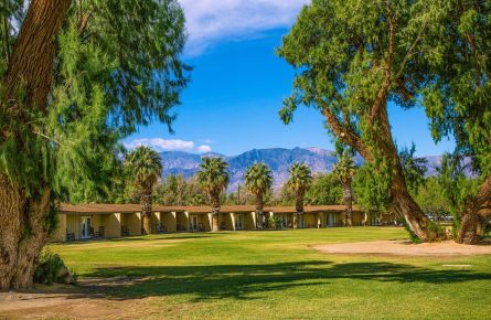 The main lawn of the Ranch at Furnace Creek is surrounded by lush vegetation.