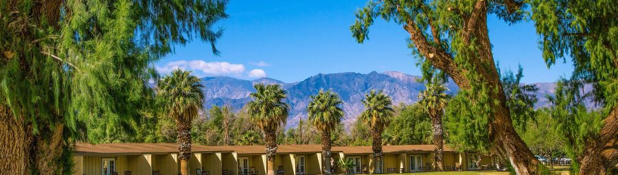 The main lawn of the Ranch at Furnace Creek is surrounded by lush vegetation.